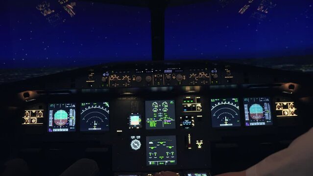 Pilots flying a plane with illuminated buttons for a flight simulator at night