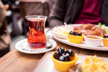 Chai and Turkish breakfast platter with bagel, olives and honey, outdoor restaurant