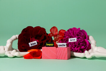 two skeleton hands holding flowers with inscriptions kiss, smile, happy, love, creative romantic design, eternal love
