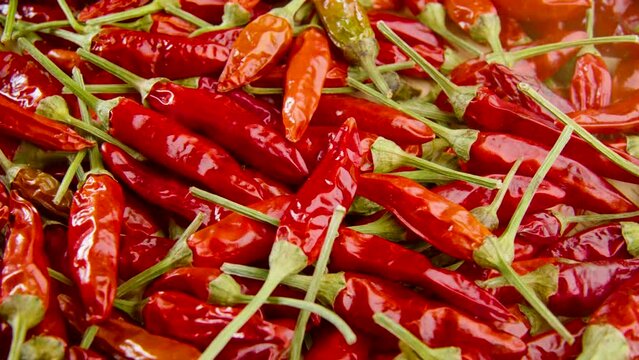 Close-up shot of scattered red hot chili peppers on a wooden table