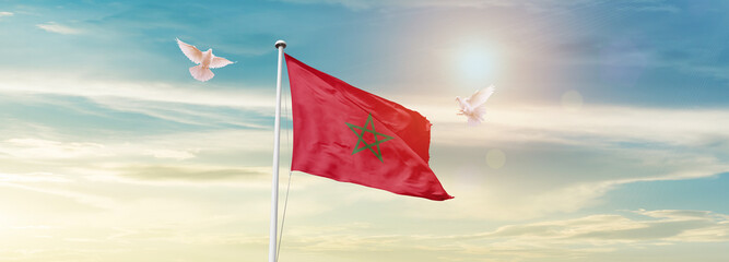 Waving Flag of Morocco in Blue Sky. The symbol of the state on wavy cotton fabric.