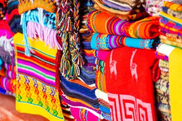 Colourful, colorful ponchos and other traditional Peruvian wool textiles at market in Aguas...