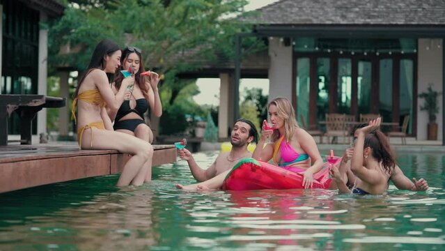 Groups of Multiculturalism Friends make an appointment to gather at  poolside party and clink glasses on holiday vacation trip at private pool villa