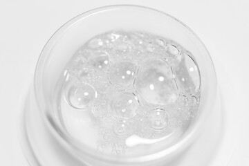 Transparent gel or liquid with bubbles in a round container