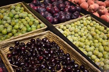 Fresh food market organic cherries, grapes and plums in baskets