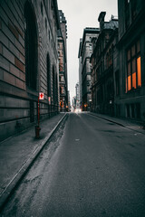 Vertical shot of an empty street between old buildings in Montreal, Ontario, Canada on a gloomy day