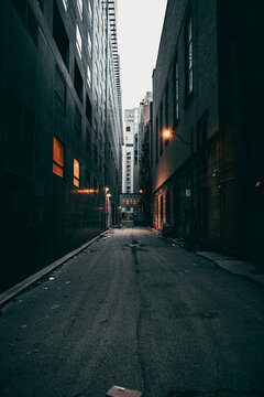 Vertical shot of an empty street between old buildings in Montreal, Ontario, Canada on a gloomy day © Comrade2m/Wirestock Creators