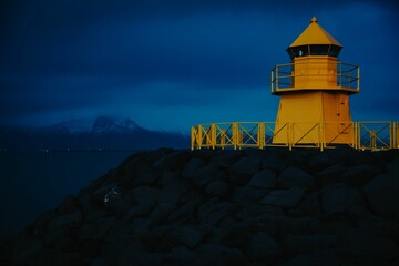 Drone shot of the yellow lighthouse of Reykjavik with a blue sky in Iceland
