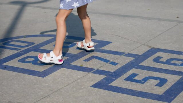 Girl playing hopscotch on playground outdoors