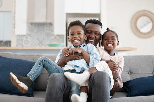 Hug, happy and portrait of a father with children on the sofa for playing, bonding and laughing. Smile, black family and an African dad hugging kids with affection on a home couch for happiness
