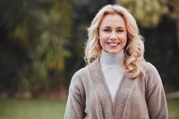 Mature woman, portrait and smile in garden, backyard or park with winter fashion in morning,...