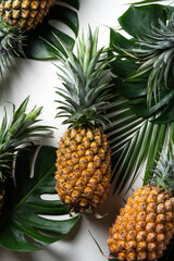 Obraz premium Fresh pineapple with tropical leaves on white background.
