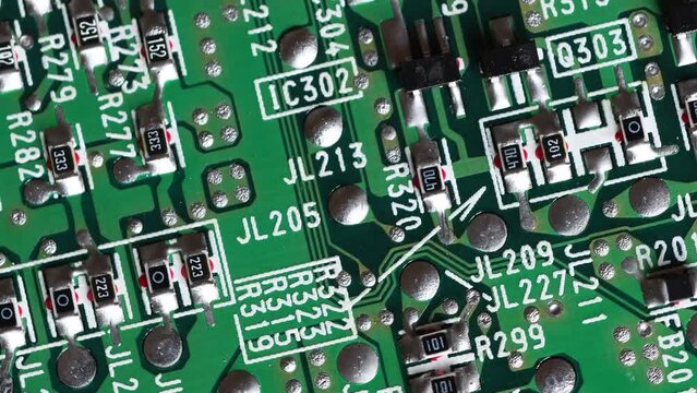 Circuit board with components in rotation. Extreme close up of green electronic board, with electronic components.