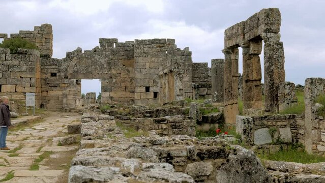 Pan shot to female tourist visiting unesco ancient Turkish city hierapolis