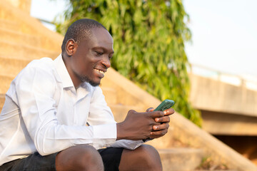 A man sitting on steps looking at his cell phone