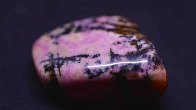 Macro shot of rhodonite mineral on purple background