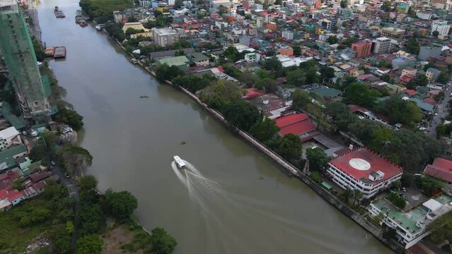 Aerial view of a white boat cruising through Pasig River in the Philippines