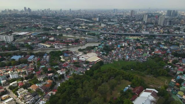 Aerial of crowded residential buildings and Pasig River in the center of Manila, Philippines