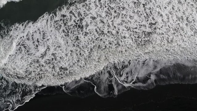 Beautiful view of Blach Beach with foamy waves in Vik, Iceland