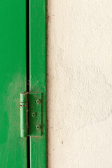 An old green hinge in a wall