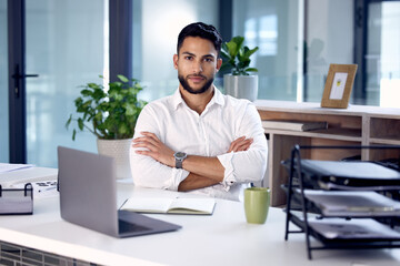 Fototapeta na wymiar Portrait, laptop and man with arms crossed, business and employee in a modern office, serious and startup success. Face, male person and entrepreneur with a pc, career and professional in a workplace