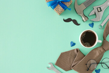 Father's Day honoring concept. Top view flat lay of gift box, cup of coffee, men's accessories, hand tools and hearts on teal background with blank space for text or advert