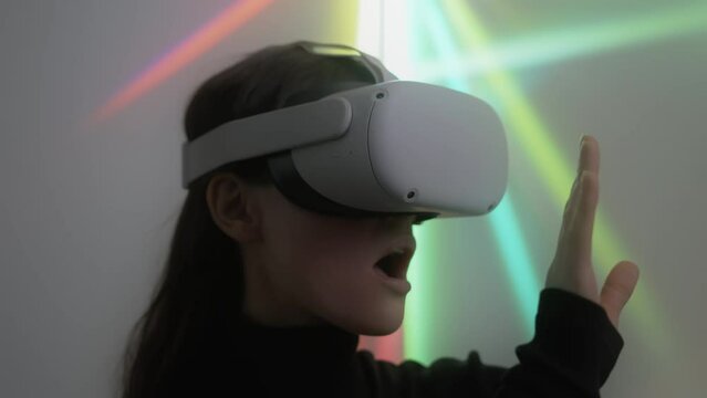 Young woman explores cyber space using vr headset and touches unreal objects. Portrait of female gamer enjoying playing virtual reality game admiring beauty of digital 3D environment