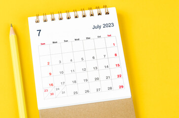The July 2027 Monthly desk calendar for 2023 with pencil on yellow background.