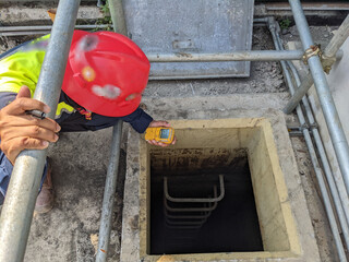 Worker and safety officer take data for gas test before confine space activity. The photo is...