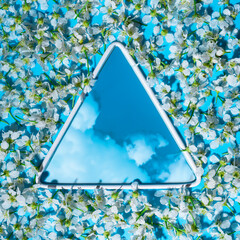 Floral arrangement with space for text, triangle with clouds and blue sky surrounded by small white...