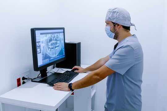 Male doctor working on computer while standing