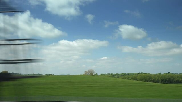 English countryside from a train window.
Fields and trees shot from a moving train window in the English Midlands.