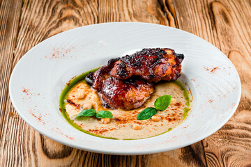 Fried chicken legs with chickpeas, basil and sauce.