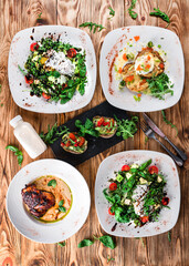 Green salads with vegetables, eggs and greens with fried chicken legs with sauce and zucchini pancakes.