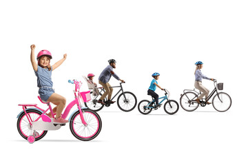 Fototapeta premium Family riding bicycles and a girl gesturing happiness on her bicycle