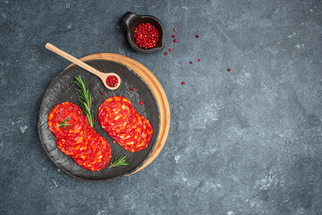 Chorizo sausage thin cut on plate on a dark background. Long banner format. top view