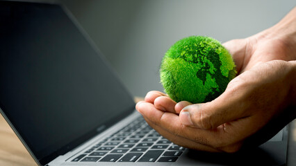 Green globe on hand with laptop keyboard Technology concept with nature concept efficient carbon technology digital sustainability Green technologies for the SDGs Sustainable Development Goals