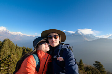 A young couple travellers trekking in Poon Hill view point in Ghorepani, Nepal.