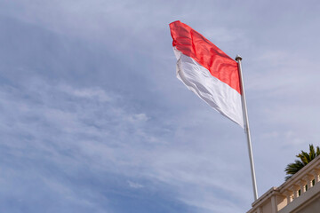 flag of Monaco against cloudy sky