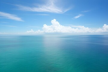 Fototapeta na wymiar 海の水面に日光が輝く、空は美しい雲と青空