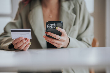 online payment Young woman's hand holding a credit card and using a smartphone for online shopping.