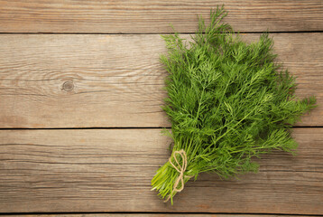 Bunch of dill on grey wooden background with space for text. Top view. Food for vegetarians