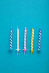 Coloruful birthday candles on blue background. Birthday celebration. Vertical photo