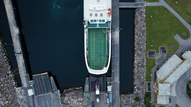 Passenger and vehicle ferry loading cars and trucks on board. Drone view on logistics operations in sea. Maritime navy transportation