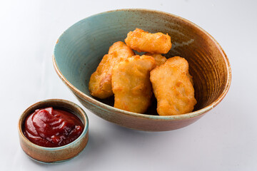 Fried chicken nuggets with ketchup sauce.