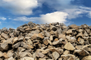 Fototapeta na wymiar Pile of basalt stones against the blue sky. Pile of volcanic rocks