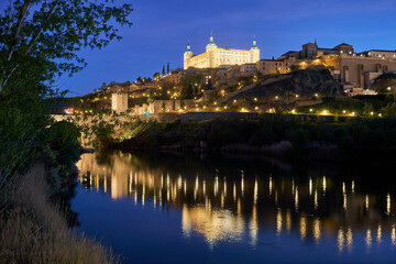 Fototapeta na wymiar A mesmerizing panoramic view of Toledo at night, overlooking the Tajo River. The illuminated cityscape showcases the city's architectural marvels, creating a captivating and enchanting scene.
