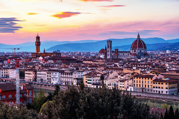 The view of the towers of the Palazzo Vecchio and the Cattedrale di Santa Maria del Fiore from Piazza Michelangelo in Florence at sunset.