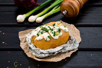 Potatoes baked in foil with sour cream, onions and herbs.
