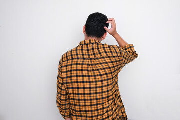 Rear view of Adult man scratching his head showing confused gesture